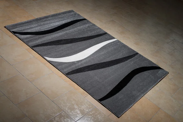 Zwarte patroon tapijt op de vloer liggen — Stockfoto