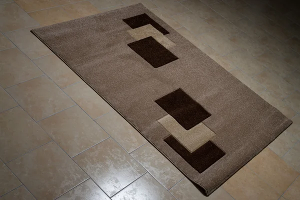 Ковер из коричневой ткани, лежащий на полу — стоковое фото