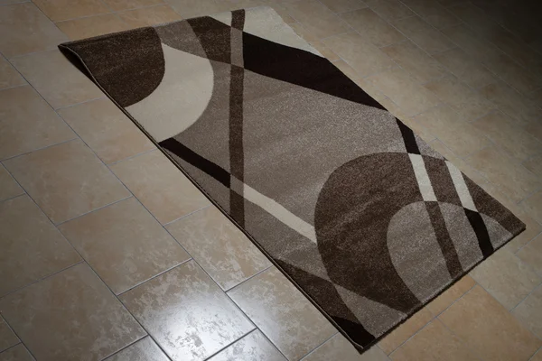 Bruine patroon tapijt op de vloer liggen — Stockfoto