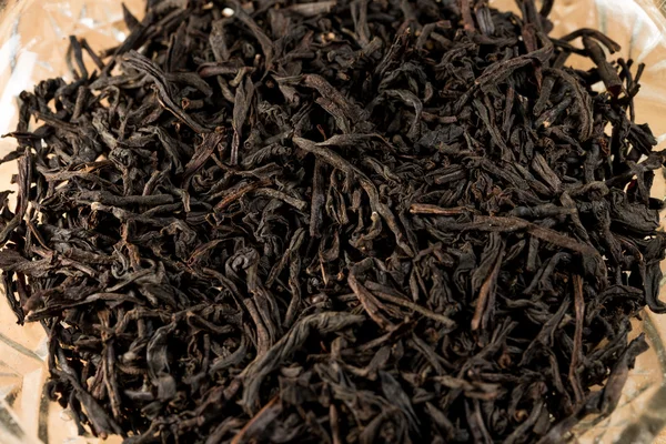 Zwarte thee bladeren in een glazen kom — Stockfoto