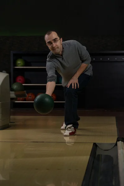 Gülümseyen genç adam bir bowling topu ile oynama — Stok fotoğraf