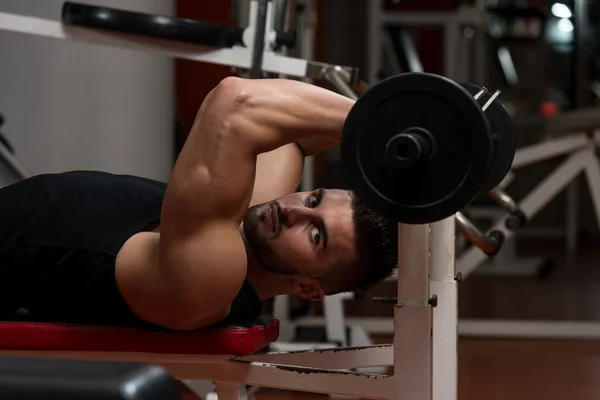 Muskulös man tränar triceps med barbell — Stockfoto