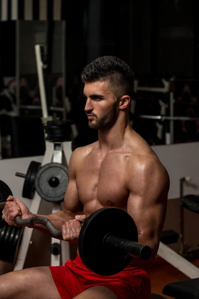 Мускулистые мужчины делают тяжелые упражнения веса для бицепсов — стоковое фото