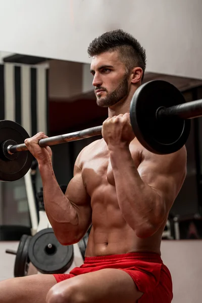 Les hommes musclés faisant l'exercice lourd de poids pour des biceps — Photo