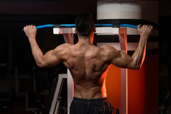 Muskulöser junger Mann beim Training im Fitnessstudio — Stockfoto