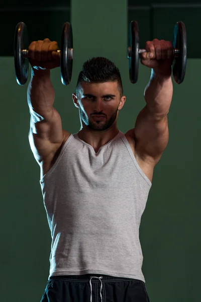 Homens musculares exercitando ombro com halteres — Fotografia de Stock