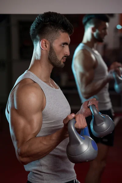 Mężczyźni w siłowni, ćwiczenia z czajnikiem dzwon — Zdjęcie stockowe