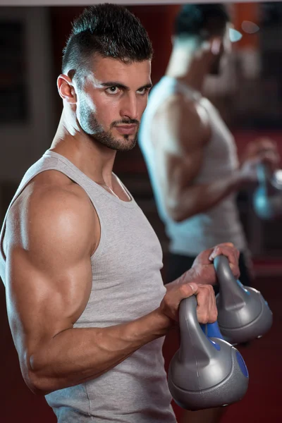 Młodzi mężczyźni podnoszenia czajnik dzwon w siłowni — Zdjęcie stockowe