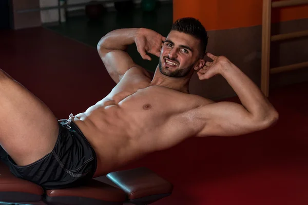 Masculino fazendo push-ups em um ginásio — Fotografia de Stock