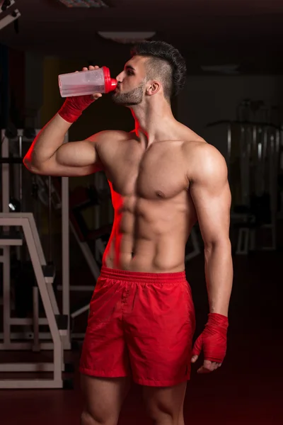 筋肉の男性は、シェーカーから水を飲む — ストック写真