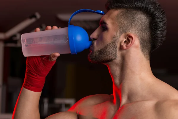 筋肉の男性は、シェーカーから水を飲む — ストック写真