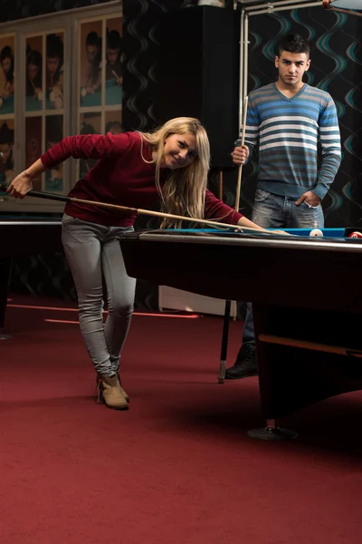 Mann lehrt Frau, wie man Pool spielt — Stockfoto