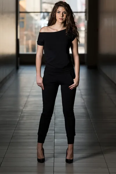 Hermosa mujer vistiendo traje de pista de moda en negro — Foto de Stock