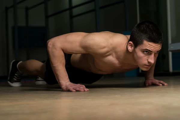 Joven haciendo flexiones — Foto de Stock