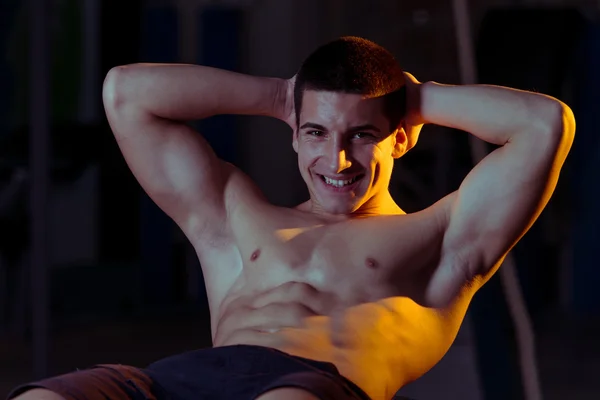 Hombres sonrientes haciendo ejercicio abdominal —  Fotos de Stock