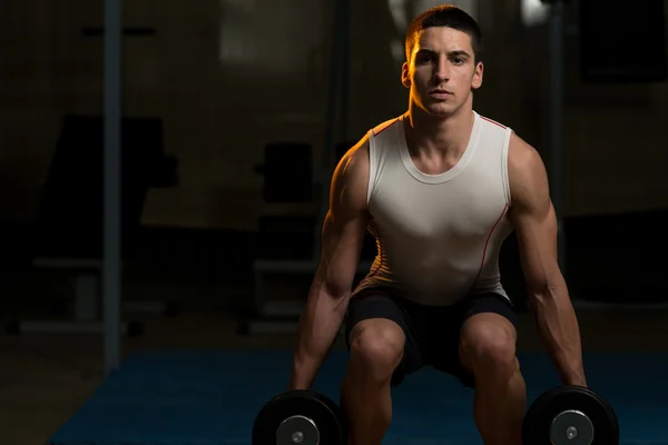 Les jeunes hommes faisant squats avec haltère dans la salle de gym — Photo