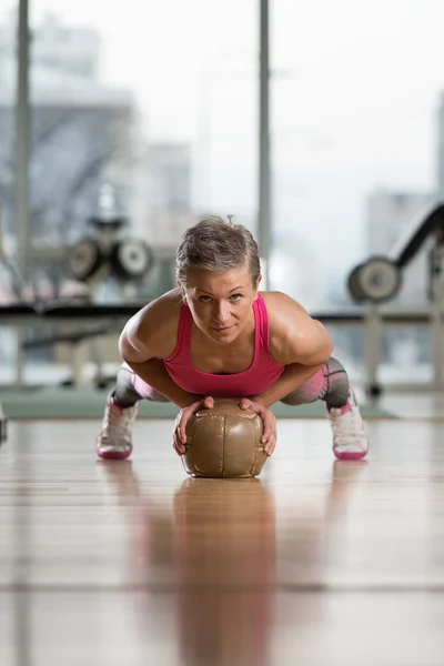 Mujer joven haciendo ejercicio Push Ups en la bola de la medicina — Foto de Stock