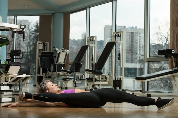 Fitness žena táhnoucí se na podlaze — Stock fotografie