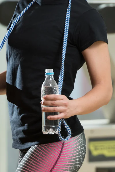 Vrouw met touw en fles water springen — Stockfoto