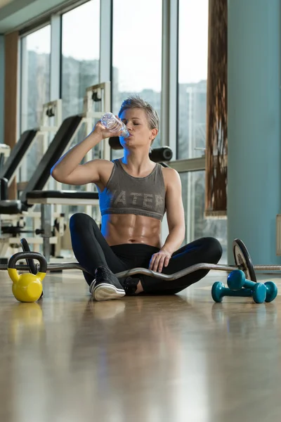 Jonge vrouw die water drinkt na inspanning — Stockfoto