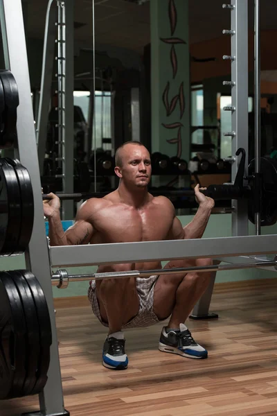 Jonge man uitvoeren barbell squats oefening voor benen — Stockfoto