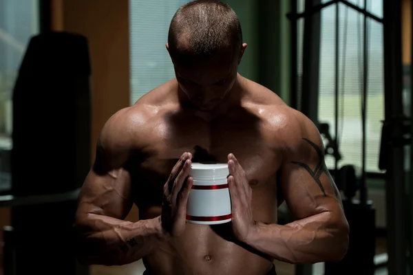 Bodybuilder Posing With Supplements For Copy Space — Stock Photo, Image