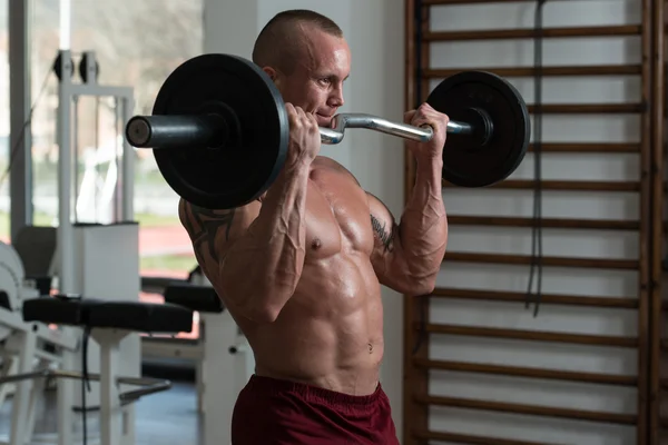 Bodybuilder uitoefening biceps met barbell — Stockfoto
