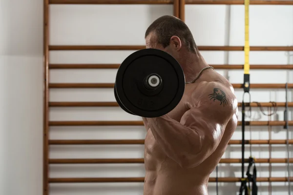 Fisiculturista exercendo bíceps com Barbell — Fotografia de Stock