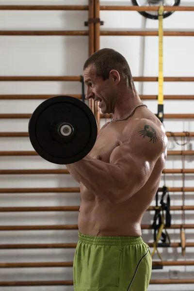 Zdrowy człowiek działa na bicepsów w centrum odnowy biologicznej — Zdjęcie stockowe