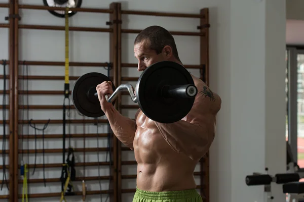 Hombre saludable ejercitando bíceps en un club de salud —  Fotos de Stock