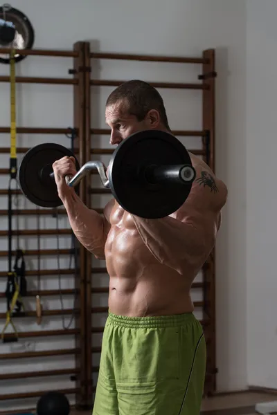 Hombre saludable ejercitando bíceps en un club de salud — Foto de Stock