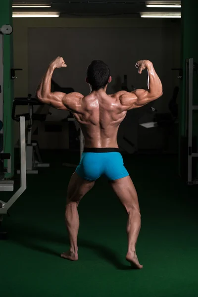 Bodybuilder effectuer arrière double biceps poses — Photo