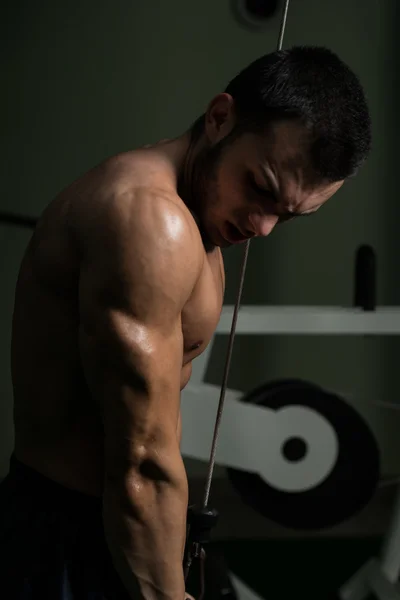 年轻男子在健身房里锻炼三头肌 — 图库照片