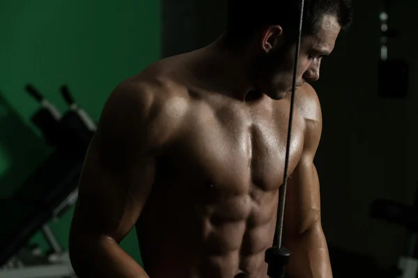 Joven ejercitando tríceps en el gimnasio — Foto de Stock