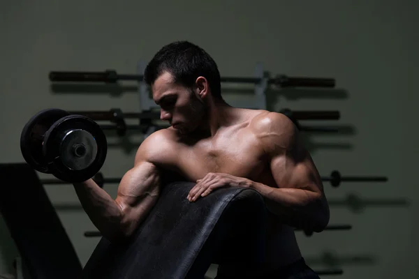 Culturista ejercitando bíceps con sombrillas —  Fotos de Stock