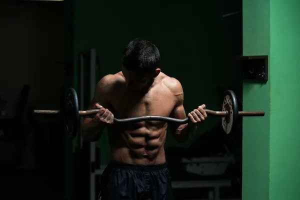 Homem levantando barbell no ginásio — Fotografia de Stock