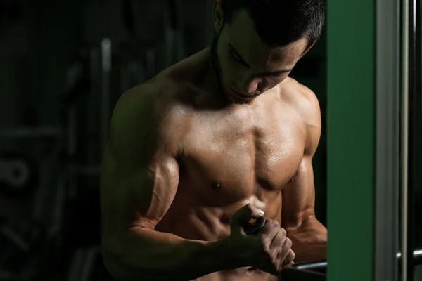 Culturista ejercitando bíceps en un gimnasio —  Fotos de Stock
