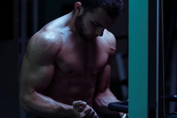 Kulturista cvičení biceps v tělocvičně — Stock fotografie