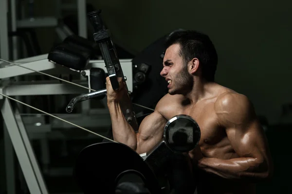 Młody człowiek robi ćwiczenia na biceps — Zdjęcie stockowe