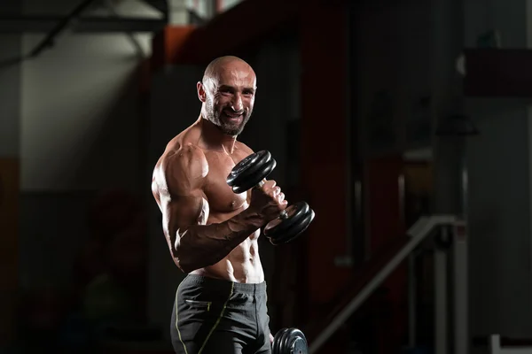 Reifer Bodybuilder trainiert Bizeps — Stockfoto