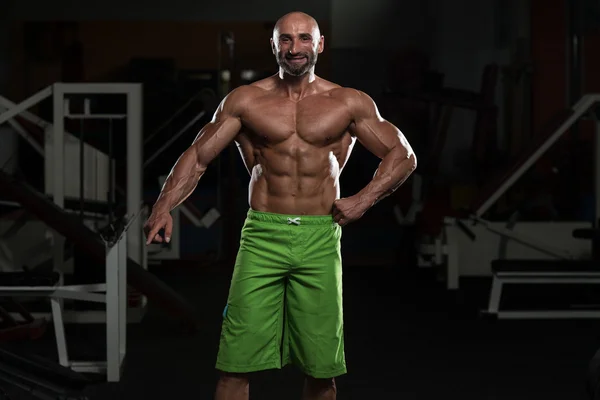 Dojrzały człowiek mięśni, wyginanie mięśni — Zdjęcie stockowe