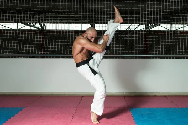 Maturo uomo fa un calcio in kimono — Foto Stock