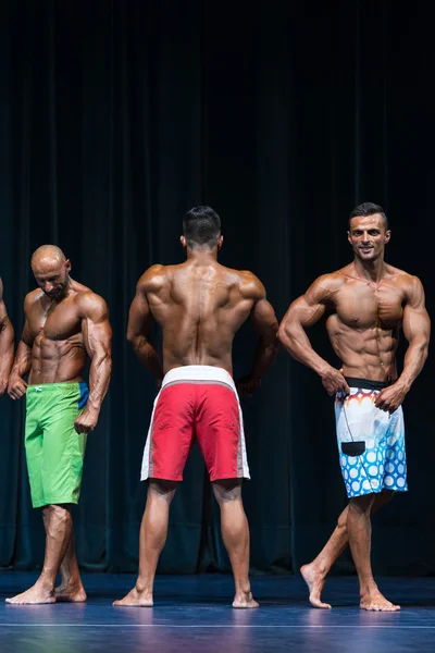 Hommes Physique posant lors d'une compétition de bodybuilding — Photo