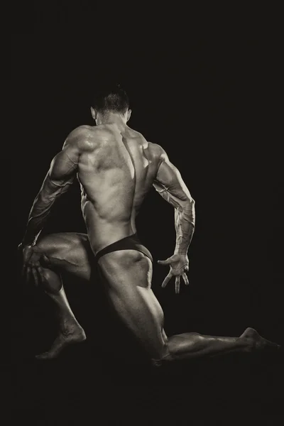 Hombres musculares flexionando los músculos sobre fondo negro —  Fotos de Stock