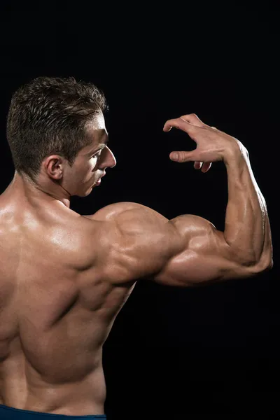 Bodybuilder zeigt Bizeps — Stockfoto