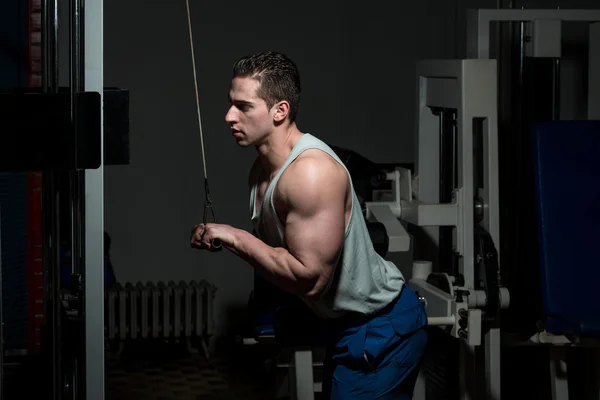Młody człowiek wykonując triceps w klubie zdrowy — Zdjęcie stockowe