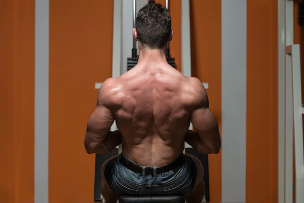 Junger Mann macht Rückengymnastik im Fitnessstudio — Stockfoto