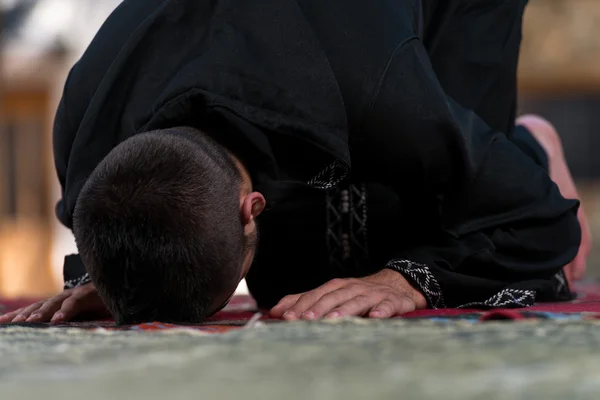 Muslimsk man i dishdasha ber i moskén — Stockfoto