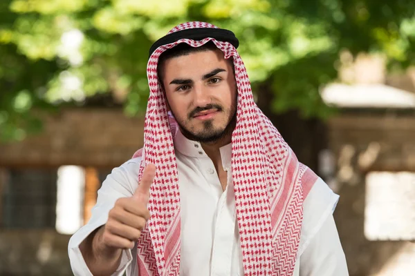 Árabe saudita homem segurando polegares para cima — Fotografia de Stock