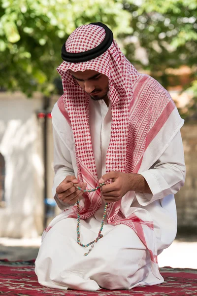 Muslimsk mann ber ved moskeen – stockfoto